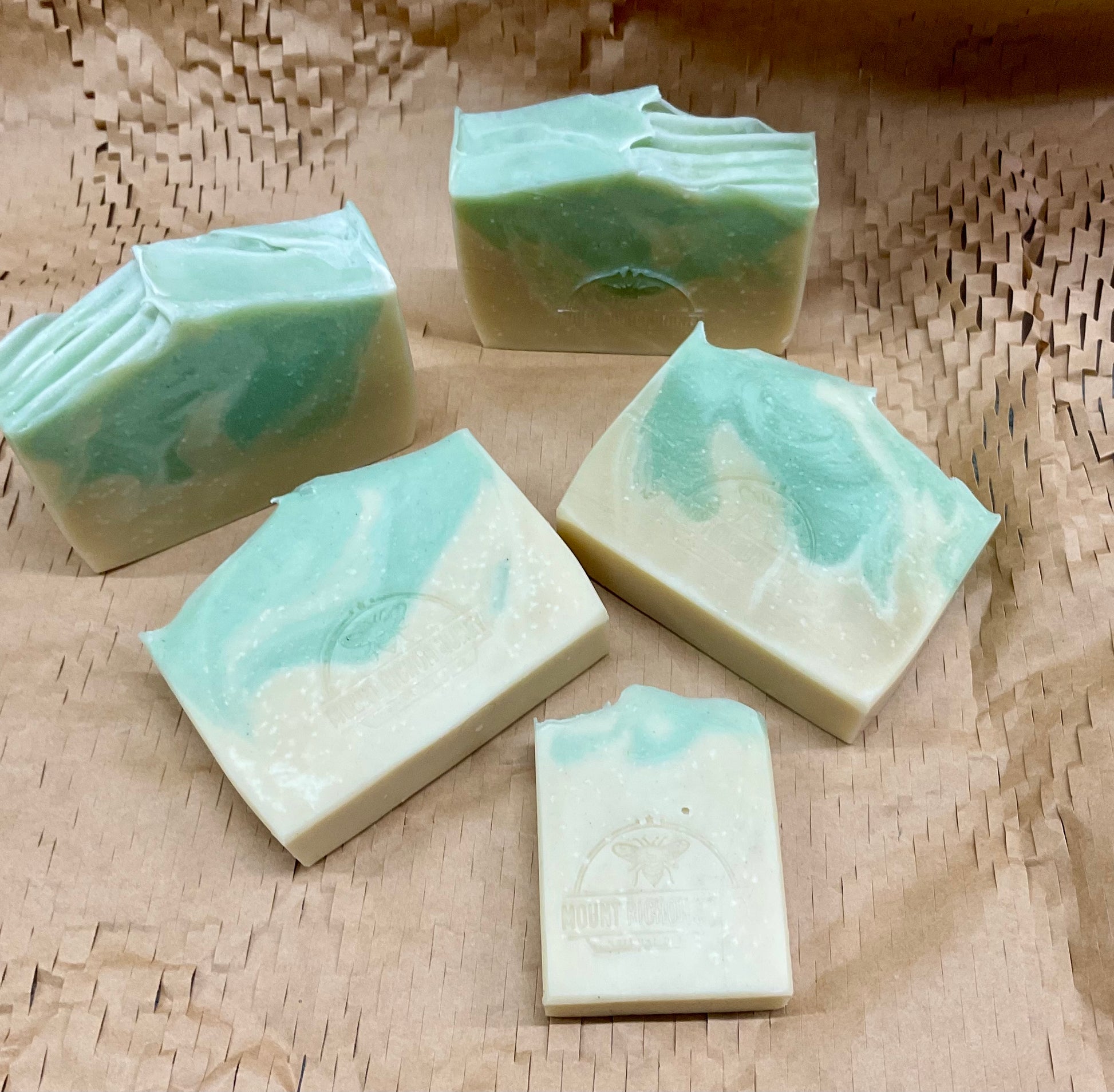 A sunlit bloom rising from red earth—Outback Bloom soap cradled in clay and light.